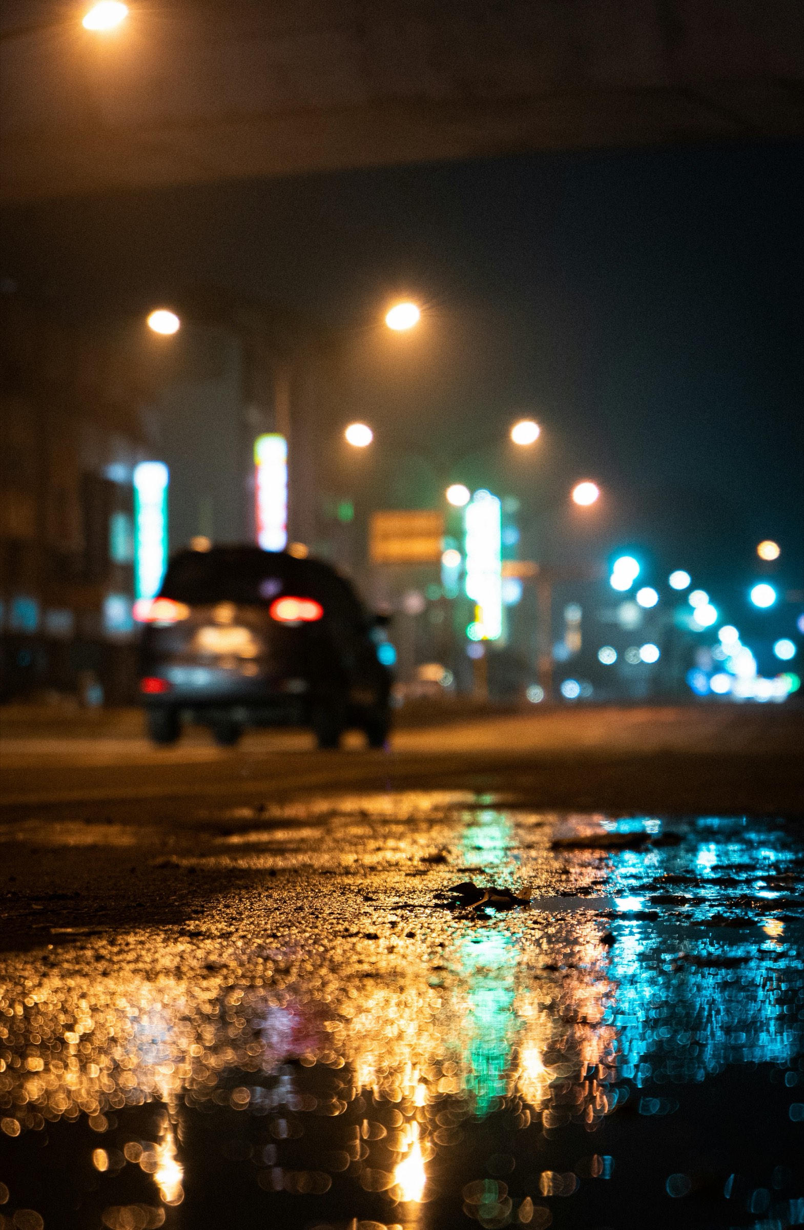 A wet city street at night, lights out of focus